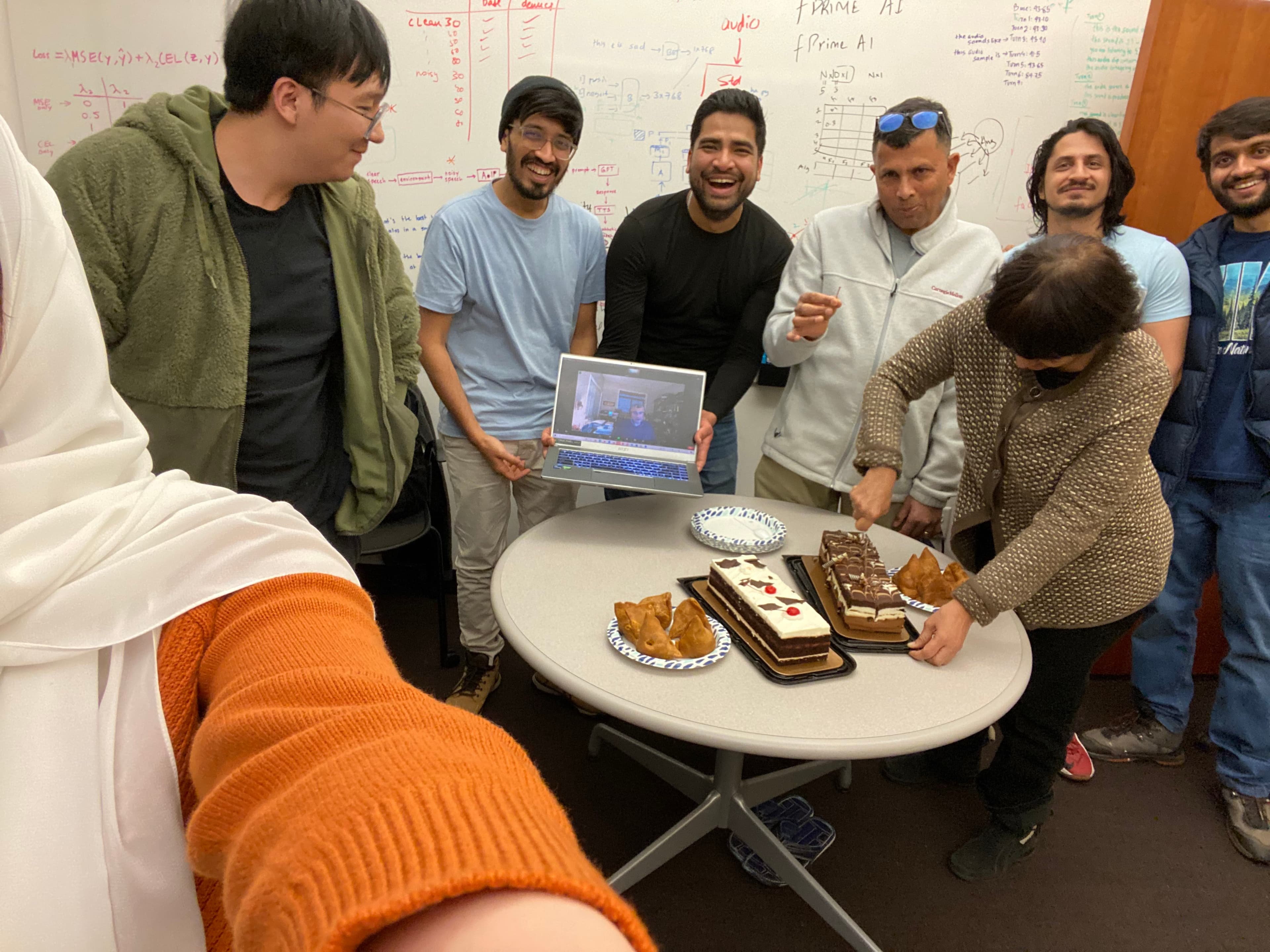 The FPrime AI team gathered around a table in the office